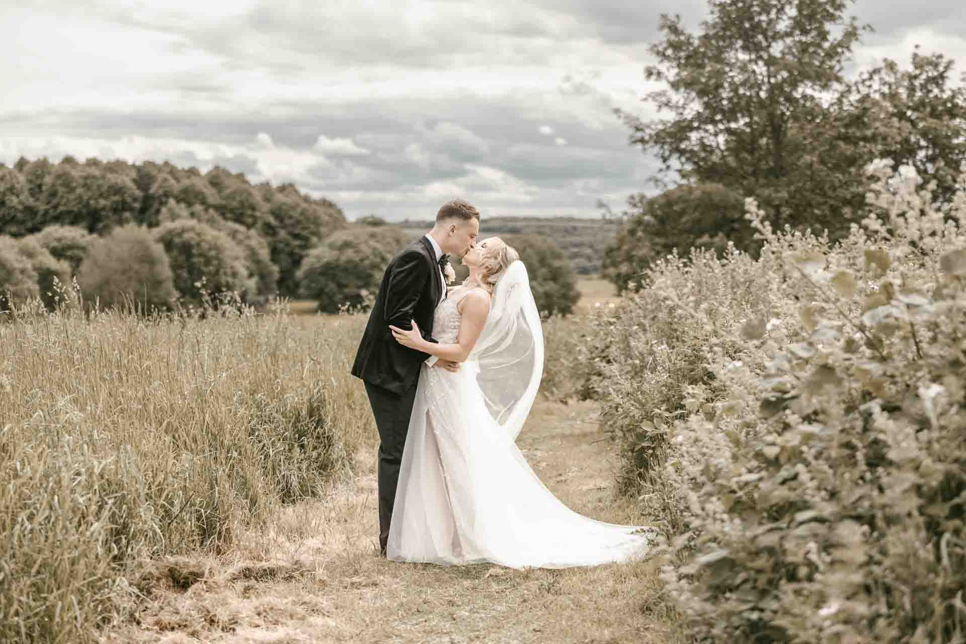 bride and groom in a field in the grounds of aston hall sheffield